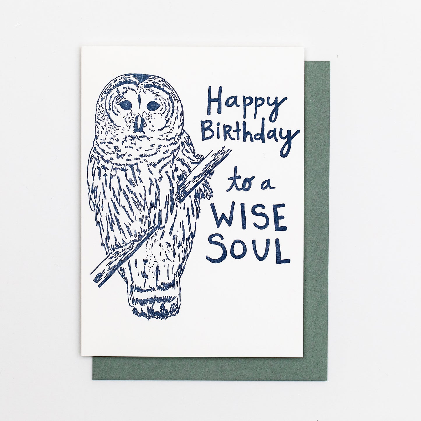 Letterpress greeting card featuring a hand-drawn barred owl printed in a lovely navy ink. The right side of the card says "Happy Birthday to a wise soul!" in a whimsical hand-drawn text, in the same navy ink. The card is white, blank inside, and is paired with a slate grey envelope.