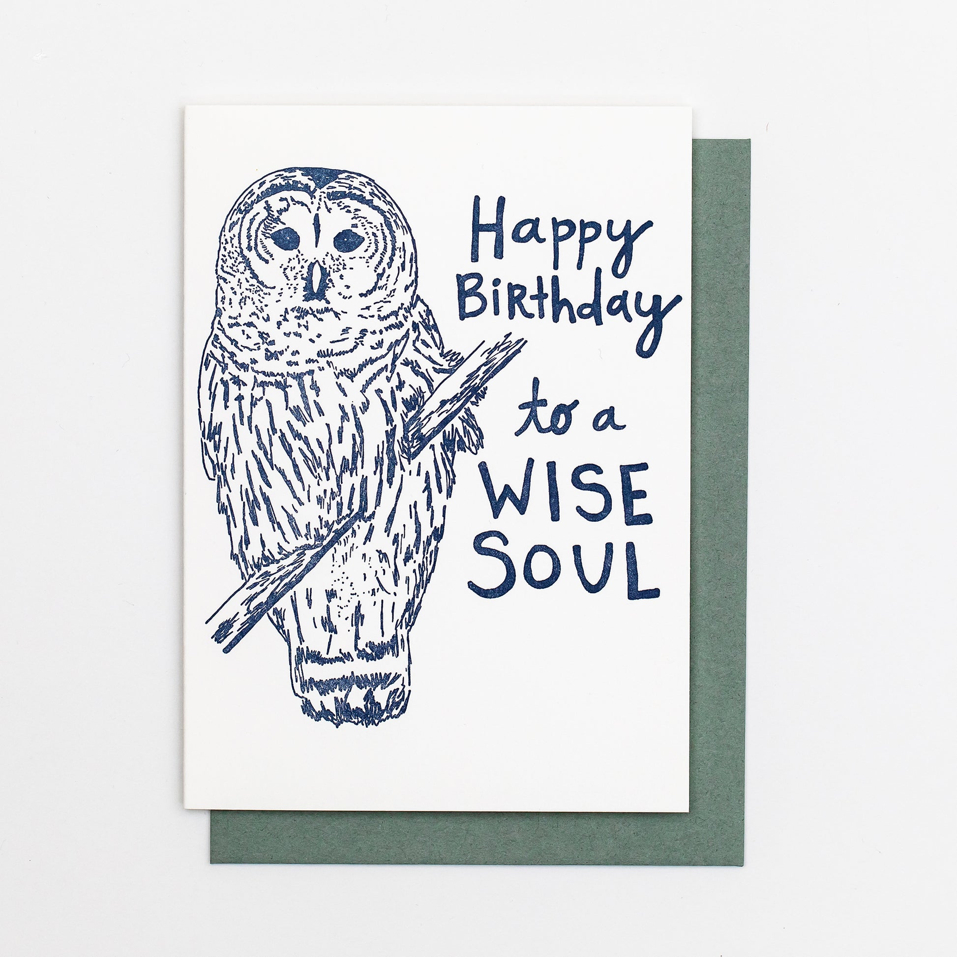 Letterpress greeting card featuring a hand-drawn barred owl printed in a lovely navy ink. The right side of the card says "Happy Birthday to a wise soul!" in a whimsical hand-drawn text, in the same navy ink. The card is white, blank inside, and is paired with a slate grey envelope.