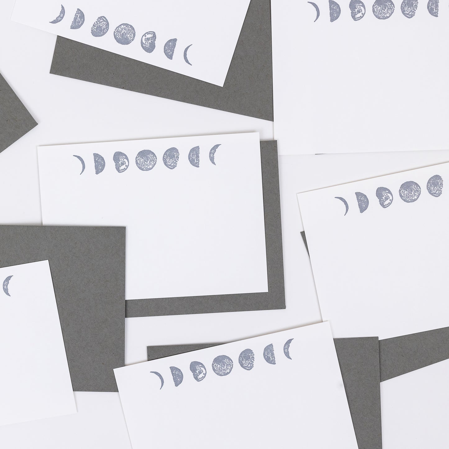 Set of 10 Letterpress Note Cards featuring hand-drawn Moon Phases letterpress printed in a shimmery silver ink onto 100% cotton paper. Includes 10 rich grey envelopes. Size A6.