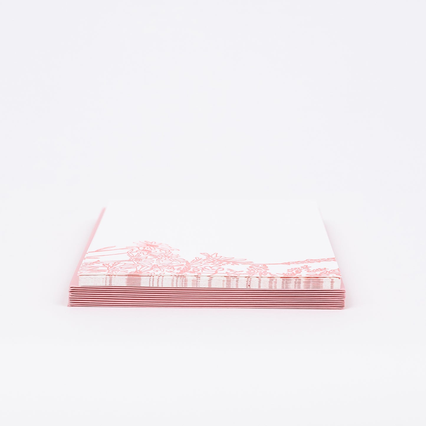 Set of 10 Letterpress Note Cards featuring a hand-drawn Wildflower Bouquet letterpress printed in a soft pink ink onto 100% cotton paper. Includes 10 soft pink envelopes. Size A6. The cards are stacked on the envelopes shown on a white background.