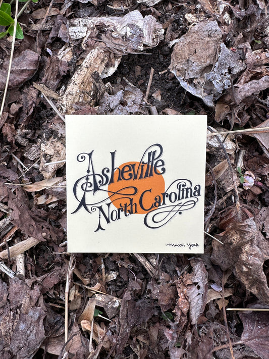 This square vinyl sticker is a tribute to two things I really love - Asheville, North Carolina and Neil Young's "Harvest." The iconic typography of the album art has been reimagined into the words Asheville North Carolina. The typography is hand-drawn by Macon York. 3" x 3" Vinyl Sticker. Sticker is shown outside on a bed of winter leaves.