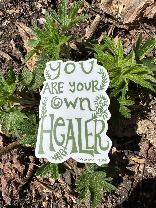High quality vinyl sticker featuring original hand-drawn typography by Macon York that reads "you are your own hearler" in a funky, earthy, 70s style. 3" x 4". Sticker is shown on new growth motherwort.