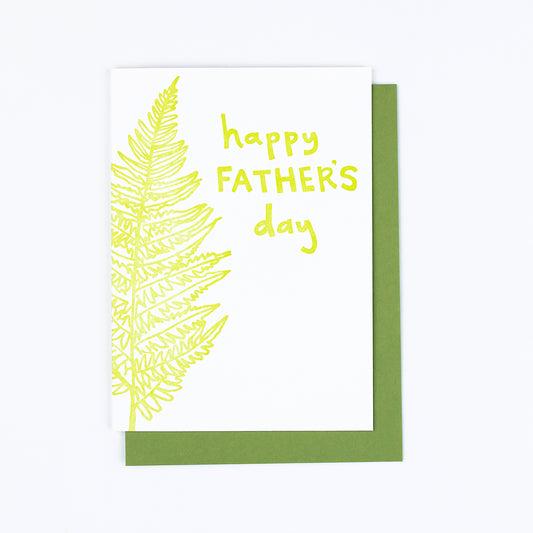 Letterpress greeting card featuring a hand-drawn fern, printed in a vibrant lime green ink. The top right of the card says "Happy Father's Day" in a whimsical hand-drawn text, in the same lime green ink. The card is white, blank inside, and is paired with a green envelope.