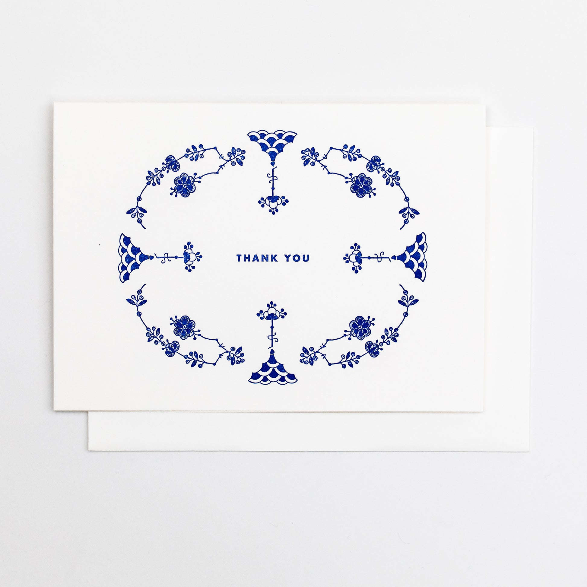 Letterpress greeting card featuring hand-drawn Furnivals Denmark Blue china pattern design, printed in a vibrant royal blue ink. Text saying "thank you" is shown centered on the card, in the same blue ink. The card is white, blank inside, and is paired with a white cotton envelope. Design is similar to Royal Copenhagen.
