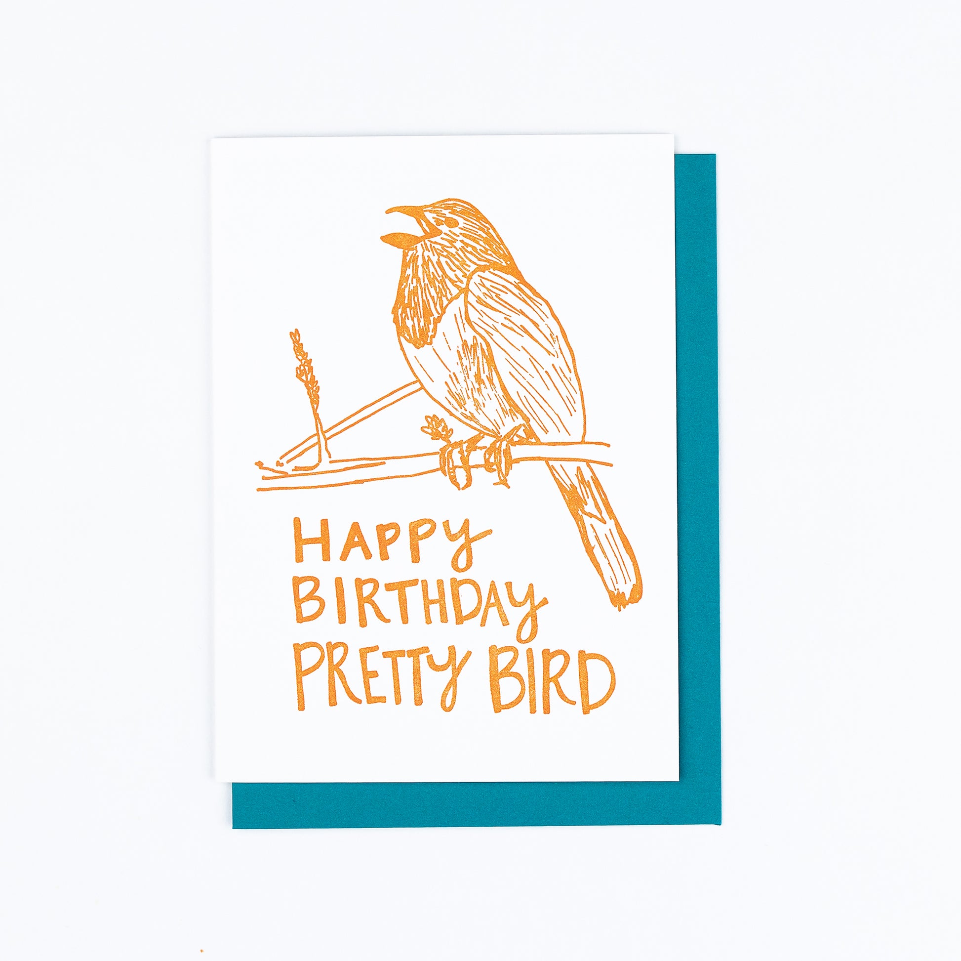 Letterpress greeting card featuring a hand-drawn Eastern towhee printed in a vibrant dark orange ink. The bottom of the card says "Happy Birthday Pretty Bird!" in a whimsical hand-drawn text, in the same dark orange ink. The card is white, blank inside, and is paired with a deep turquoise envelope.