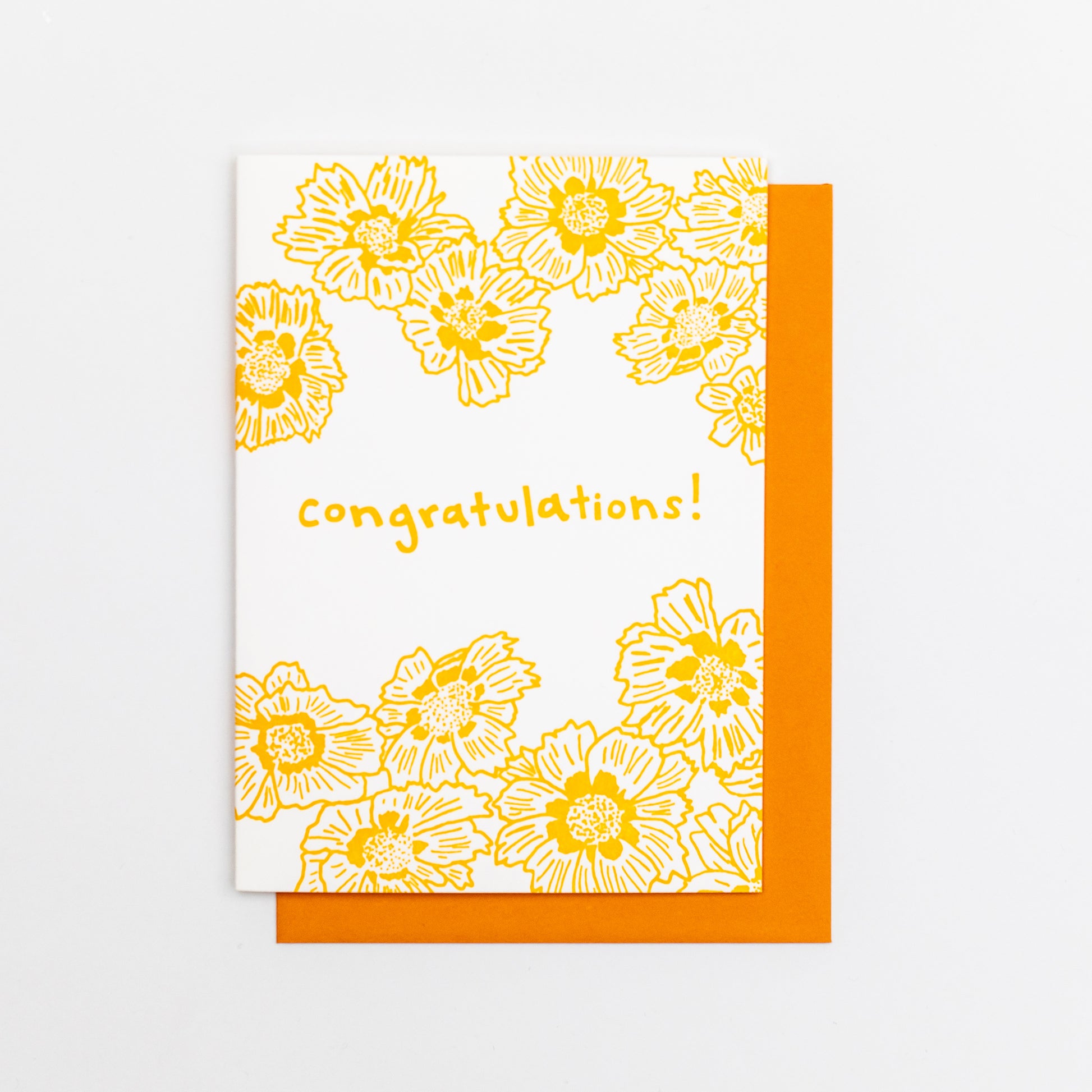 Letterpress greeting card featuring cheerful Coreopsis flowers, printed in a vibrant golden-orange ink. Whimsical hand-drawn text saying "congratulations" is shown in the center of the card, in the same golden-orange ink. The card is white, blank inside, and is paired with a fun orange envelope.
