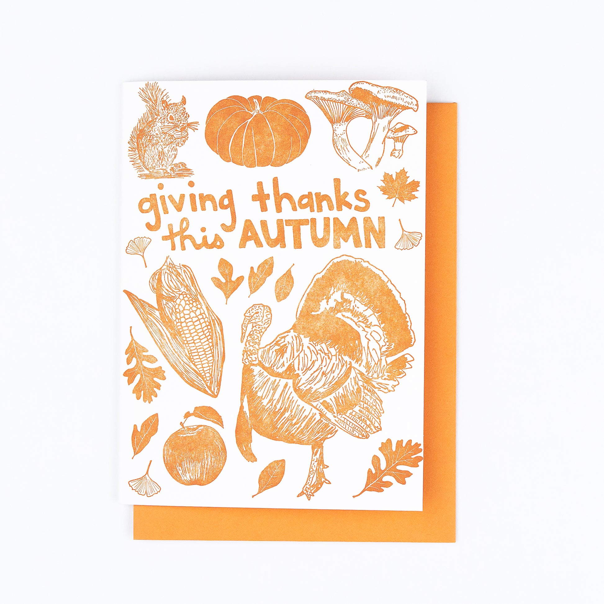 This cheerful Autumn card features all the iconic images of the fall season: squirrel, heritage pumpkin, mushrooms, fall leaves (maple, oak, sassafras, and ginkgo), a tom turkey, corn harvest, and a fresh-picked apple. Perfect for Thanksgiving. Vibrant orange ink paired with an orange envelope. Blank interior. 