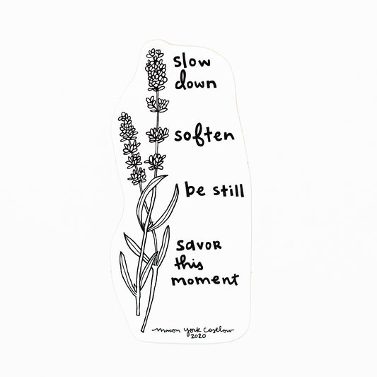 This Vinyl Sticker features original text by Macon York, hand drawn in her whimsical, folk art style. Hand-drawn lavender accompanies the text. The text reads "Slow Down. Soften. Be still. Savor this moment."